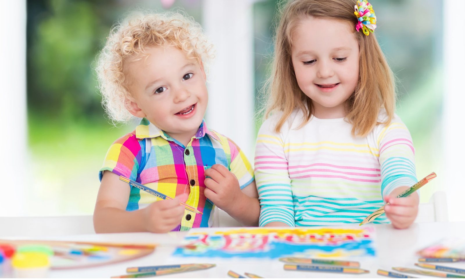 Two children drawing with ThEast rainbow pencils